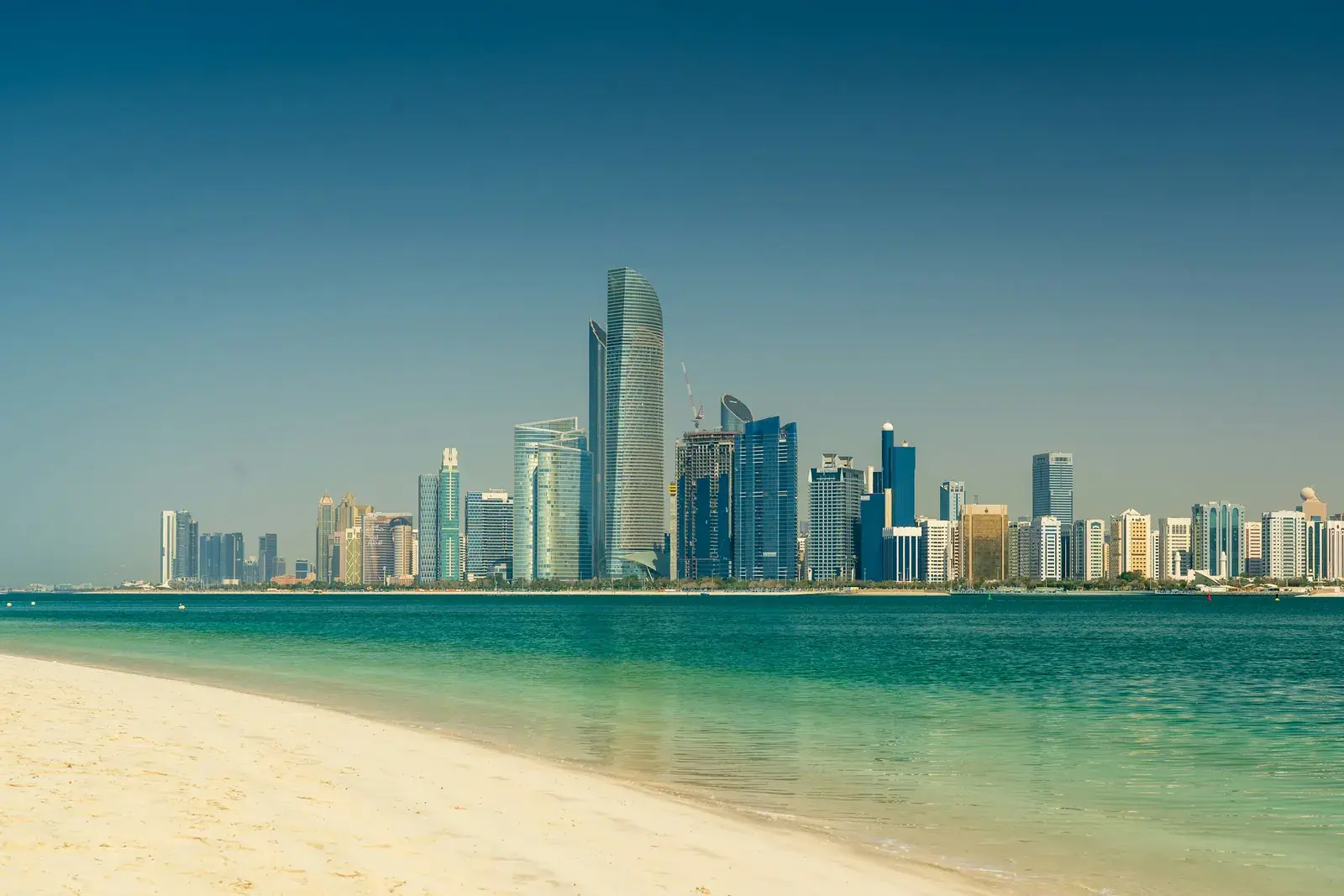 Abu Dhabi's commercial skyline seen across the water from the beach